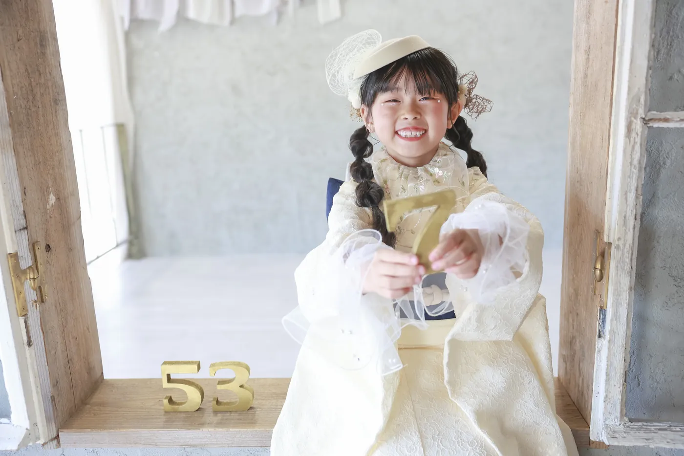 着物と帯に「7」の飾りを持つ7歳の七五三の女の子