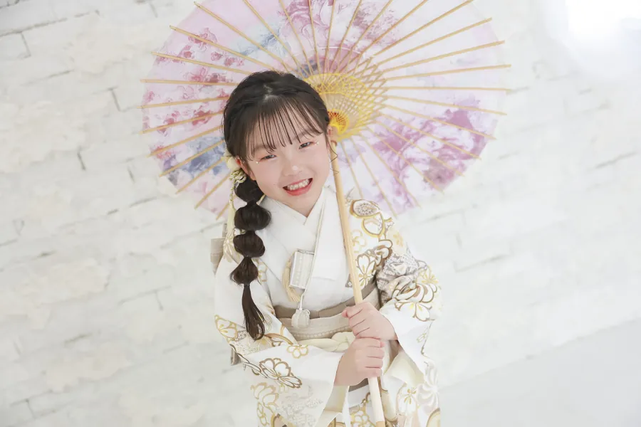 和傘を持って笑う七五三の女の子